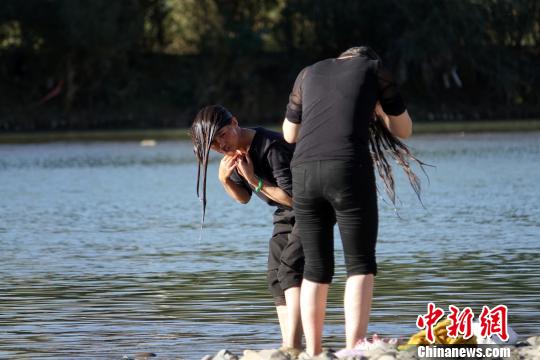 藏族姑娘在拉萨河洗头。 孙翔 摄